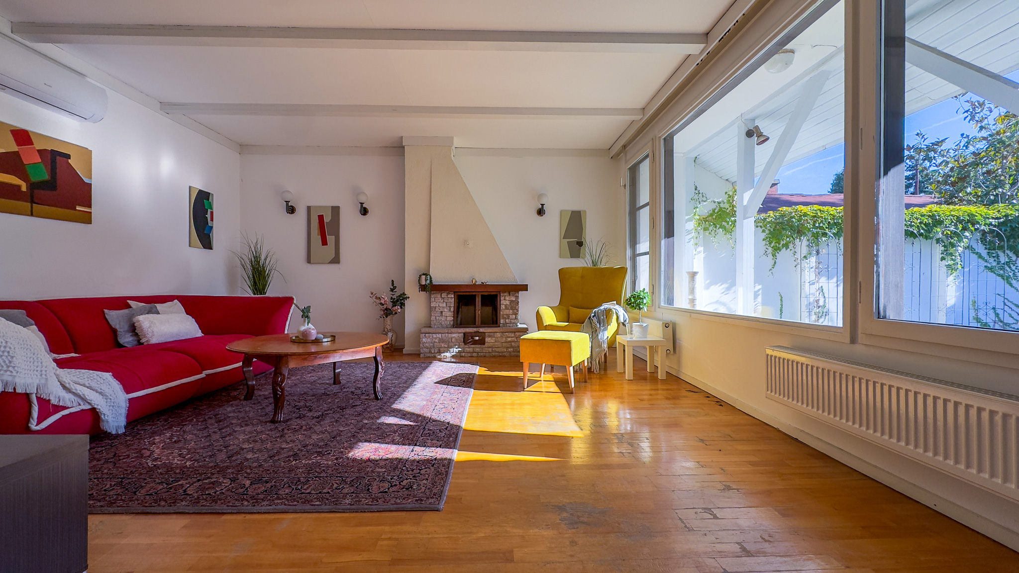 Eladott szentendrei családi ház nappalija home staging után, piros kanapéval és sárga fotellel